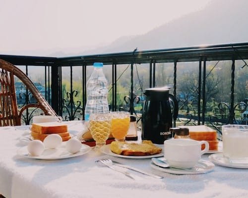 Balcony morning breakfast setting with mountain view in Pahalgam